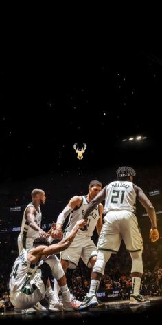 a group of men playing basketball against each other