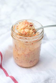 a jar filled with food sitting on top of a white towel next to a spoon