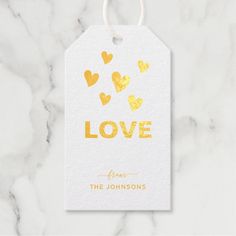 a white tag with gold foil hearts on it that says love from the johnsons