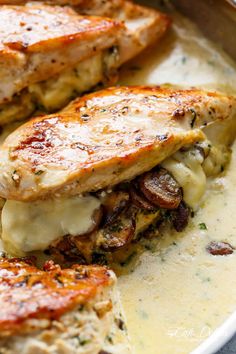 two pieces of chicken with cheese and mushrooms in a casserole on a plate