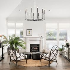 a living room filled with furniture and a fire place next to a window covered in blinds