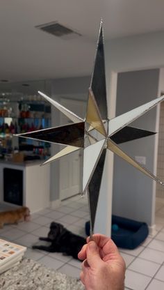 a hand holding up a metal star in a kitchen