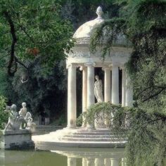 a gazebo in the middle of a pond surrounded by statues