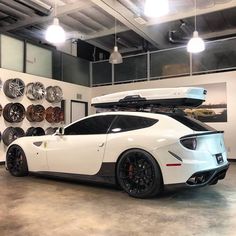 a white sports car parked in front of a wall with plates on it's back