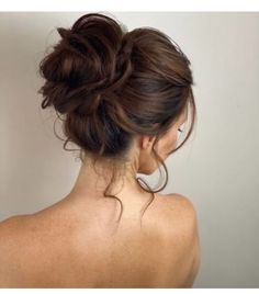 a woman with her back to the camera, wearing a messy updo hairstyle