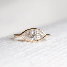 a gold ring with a pear shaped diamond