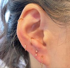 a close up of a person's ear with three different types of piercings