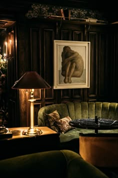 a living room filled with green couches and a painting on the wall above them