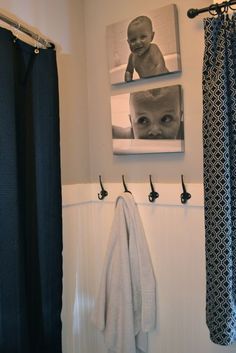 a black and white photo hangs on the wall next to a shower curtain with hooks