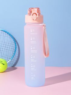 a pink water bottle next to a tennis racket and ball on a pink surface