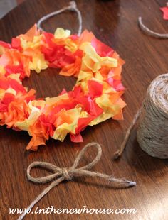 a spool of twine is next to a wreath made out of tissue paper