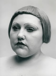 an old photo of a woman with makeup on her face and eyebrows painted to look like a doll