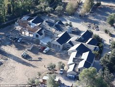 an aerial view of a large home surrounded by trees