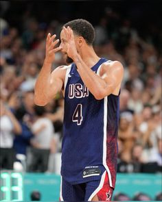 a basketball player holding his hands up in the air