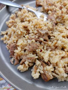 rice and meat on a plate with a spoon in the middle, ready to be eaten