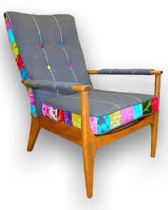 an upholstered chair with multicolored fabric on the back and armrests