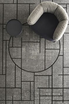 an overhead view of a black and white floor with a round chair on it's side