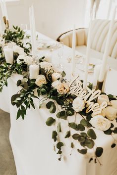 the table is set with candles, flowers and greenery for an elegant wedding reception