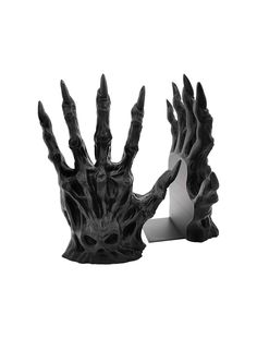 two black and white sculptures on a white background, one with hands reaching out to the other