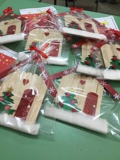 christmas decorations made out of popsicle sticks are wrapped in cellophane and tied with red ribbon