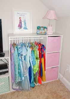 there is a closet with many different dresses hanging on the rack and a television in the corner