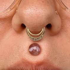 a woman's nose is shown with an unusual nose ring