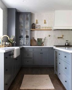 a kitchen with gray cabinets and white counter tops