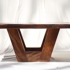 a wooden table with an unusual design on it's top and bottom, against a white background