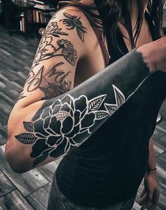 a woman with black and white tattoos on her arm