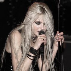 a woman with long hair holding a microphone