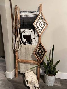 a wooden chair sitting next to a potted plant on top of a hard wood floor