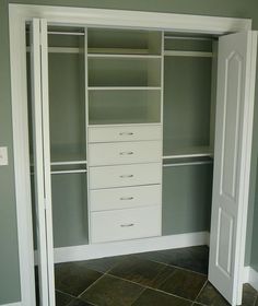 an empty walk in closet with white drawers