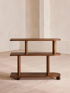 a wooden shelf sitting on top of a hard wood floor next to a white wall