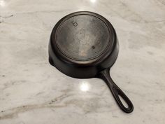 a black frying pan sitting on top of a marble counter