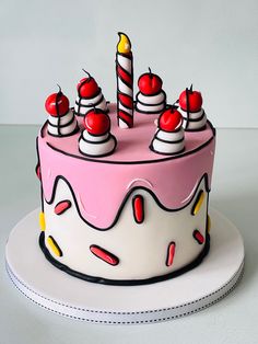 a birthday cake decorated with candles and cherries