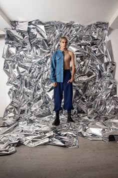 a man standing in front of a pile of shiny aluminum foil covering the walls and floor