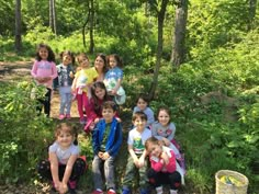 a group of children standing in the woods