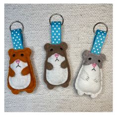 three small animal key fobs are on the carpet