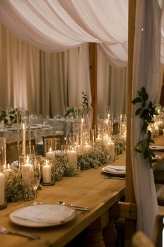 the table is set with candles and greenery