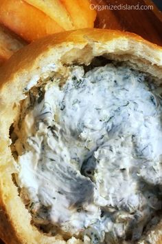 an open bread bowl filled with cream cheese