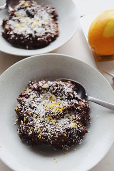 two white plates topped with dessert next to an orange