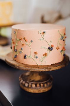 there is a pink cake with flowers on it