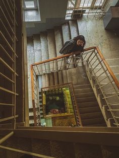 a man climbing up the side of a stair case in an industrial building with metal handrails