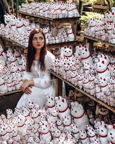 a woman sitting in front of many white teddy bears