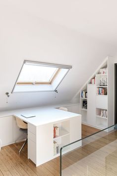 an attic office with a desk and bookshelf