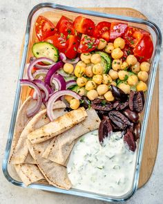 a tray filled with vegetables and pita bread