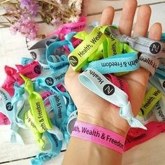 a hand holding several wristbands that say happy & freesiah on them