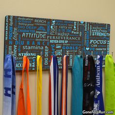 there are many medals hanging on the wall next to each other and one is blue, yellow, orange, and green