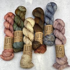 several skeins of yarn sitting on top of each other in different colors and sizes