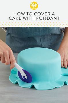 a person is decorating a cake with fondant on the table and text overlay reads how to cover a cake with fondant